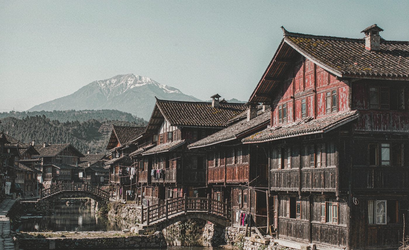 Maisons de bois le long d’un canal, montagne enneigée au fond