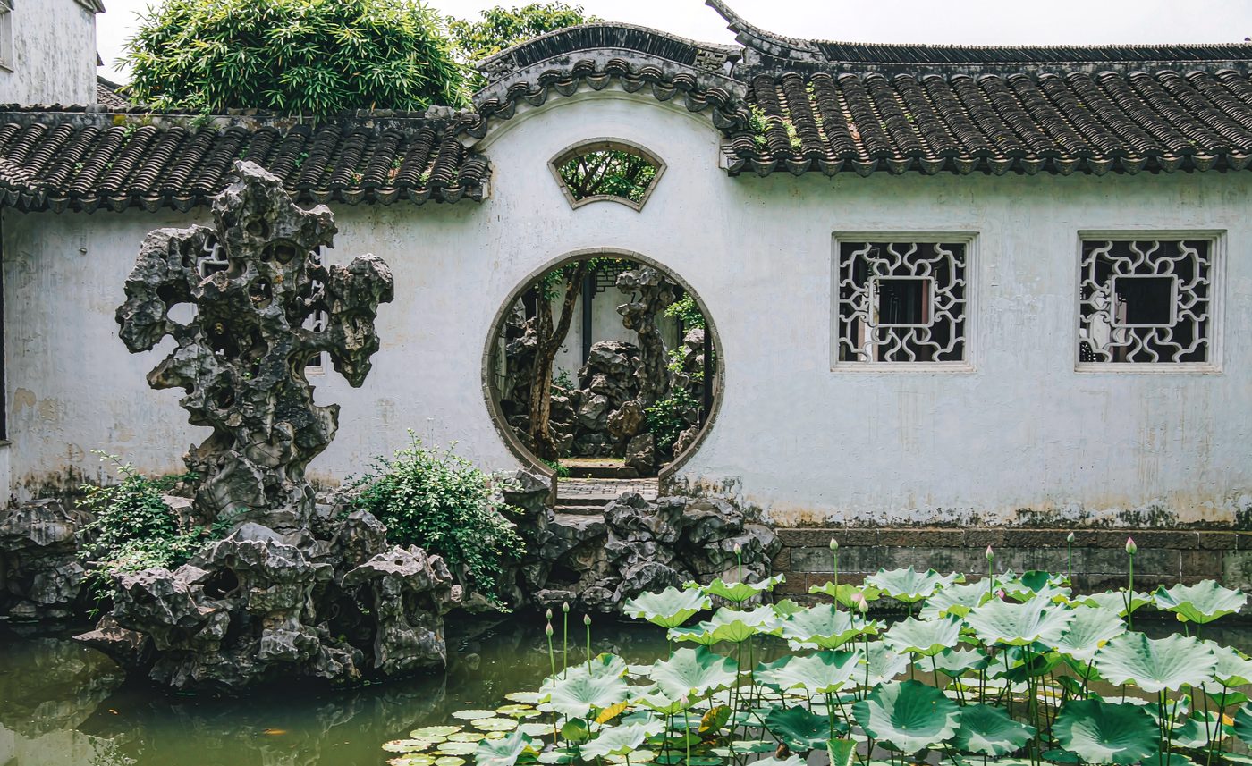 Cour de jardin classique avec porte de lune et rocailles